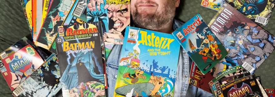 Joel Harley posing with comics for The Guardian