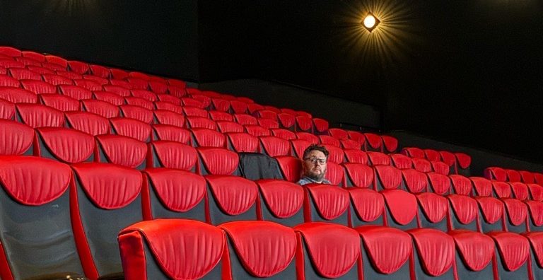 Joel Harley sitting in the cinema, watching a movie